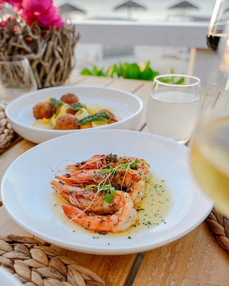 A beautifully plated prawn dish paired with wine, set on a tropical outdoor table - Tamarind Hills Resort and Villas - Antigua