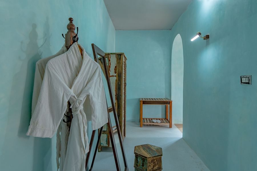 alt-text An image of a bathrobe hanged in a corner of the room where there is also a wardrobe