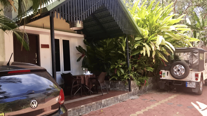 Facade of an accommodation with cars parked in front of it at Coorg Jungle Camp Backwater Resort, Kushalnagar.