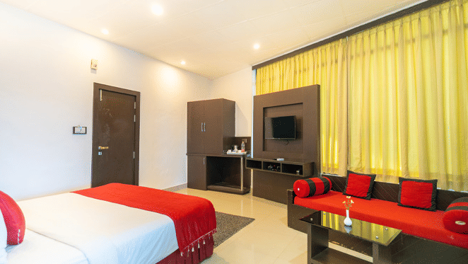 Image of a room with a bed and a sofa in front at Coorg Jungle Camp Backwater Resort, Kushalnagar.