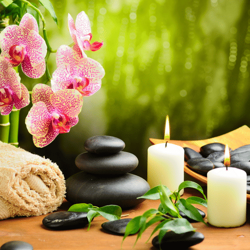 a candle, a flower and other healing objects kept in a spa