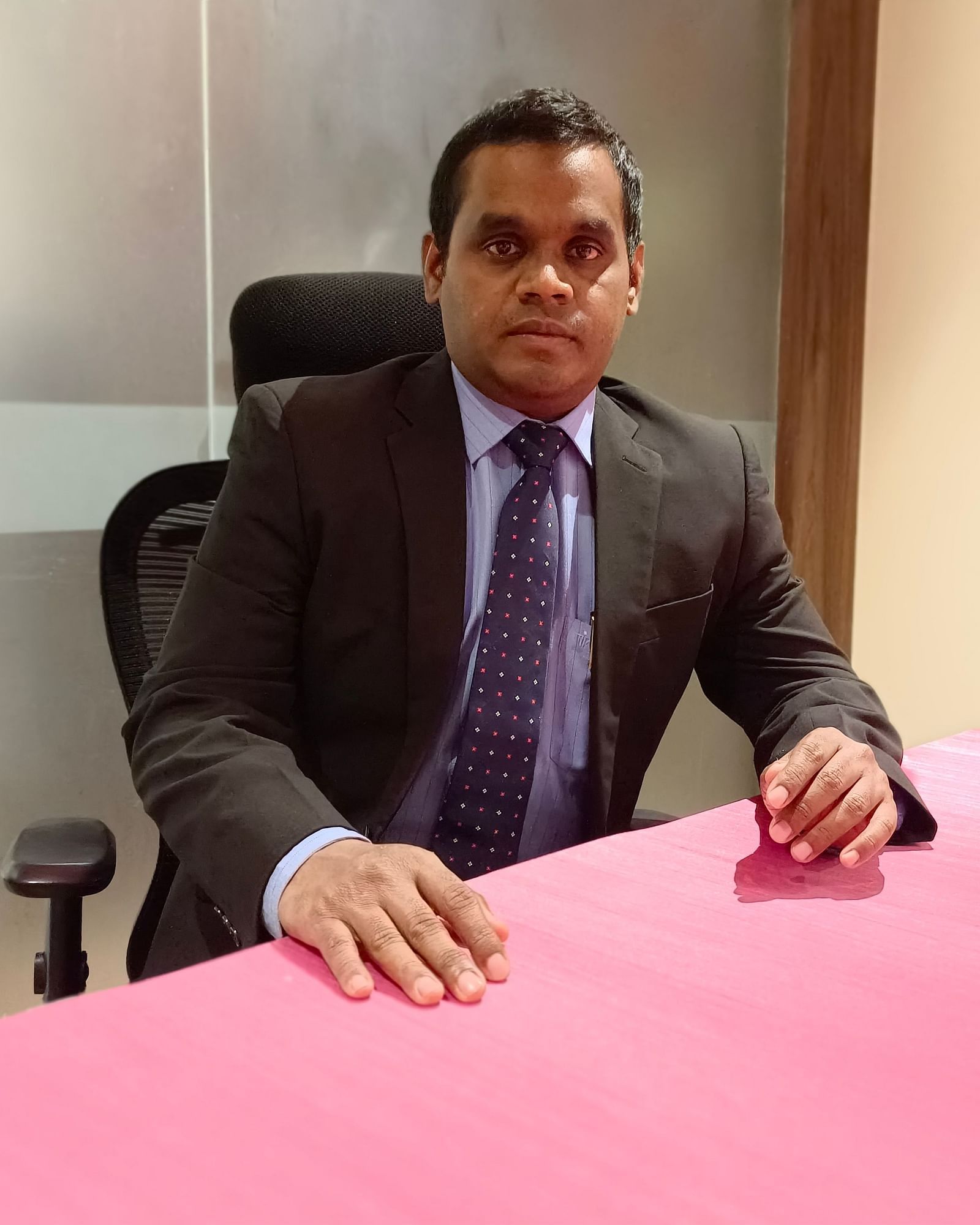  Mr Amin sits at his desk, focused and composed