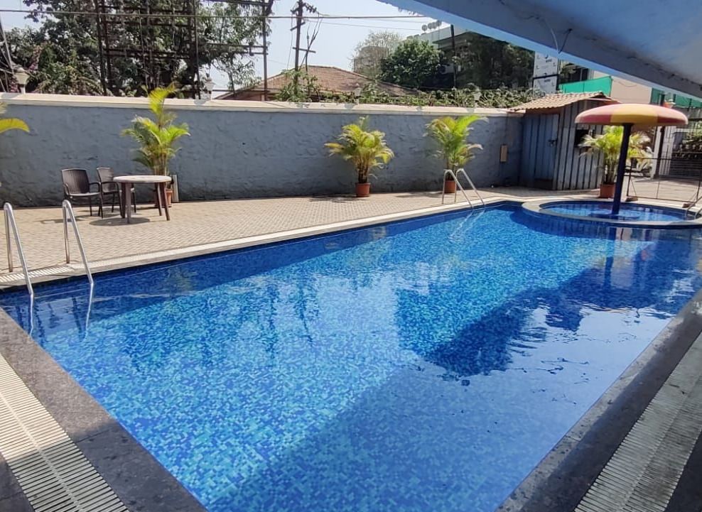 Outdoor swimming pool of Highland Resort featuring a spacious pool deck, and a children's pool canopied by an umbrella.
