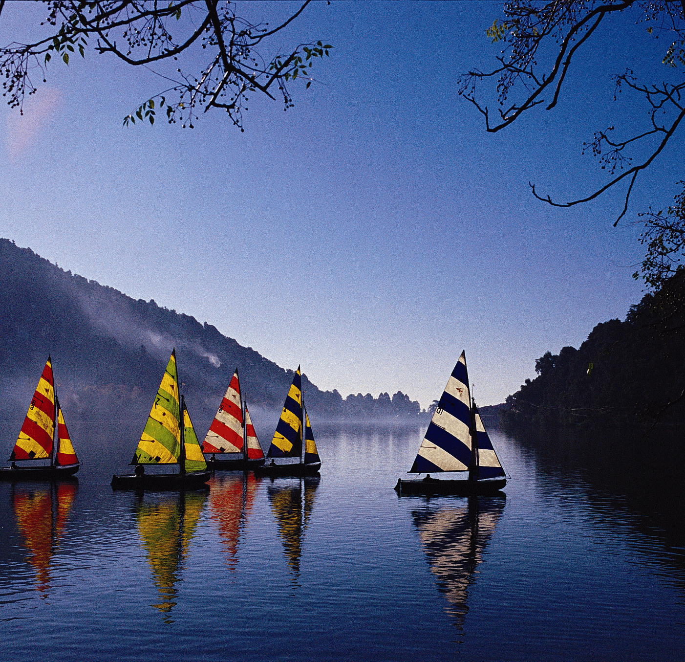 Colorful paddleboats on a lake at sunset.