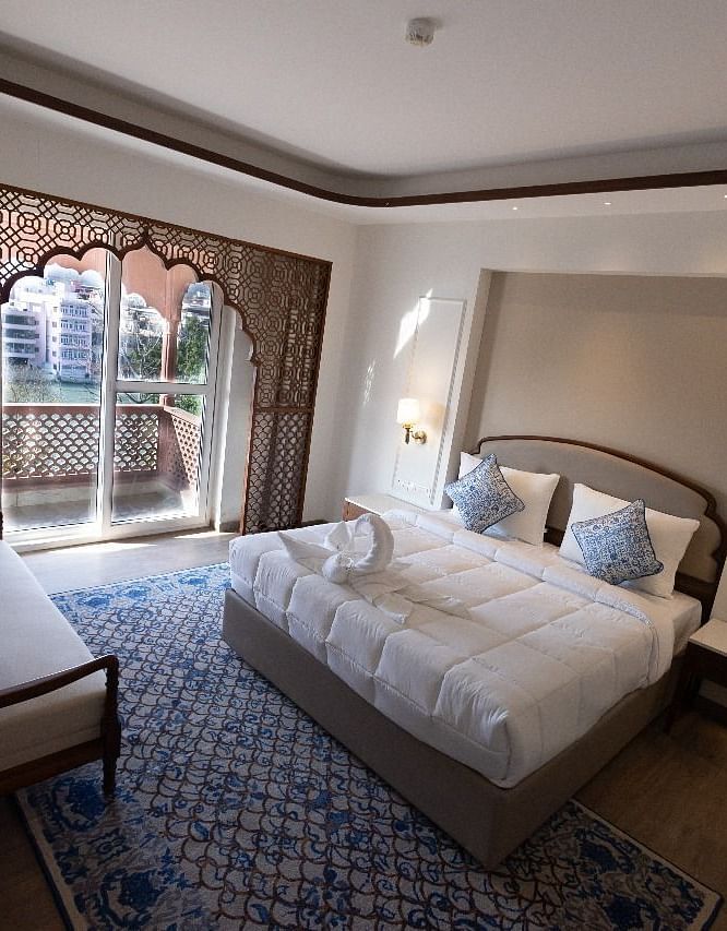 Top view shot of the Jalrupa Room featuring a double bed and a small balcony with huge french windows at Bhagirathi by RDB Atishay.