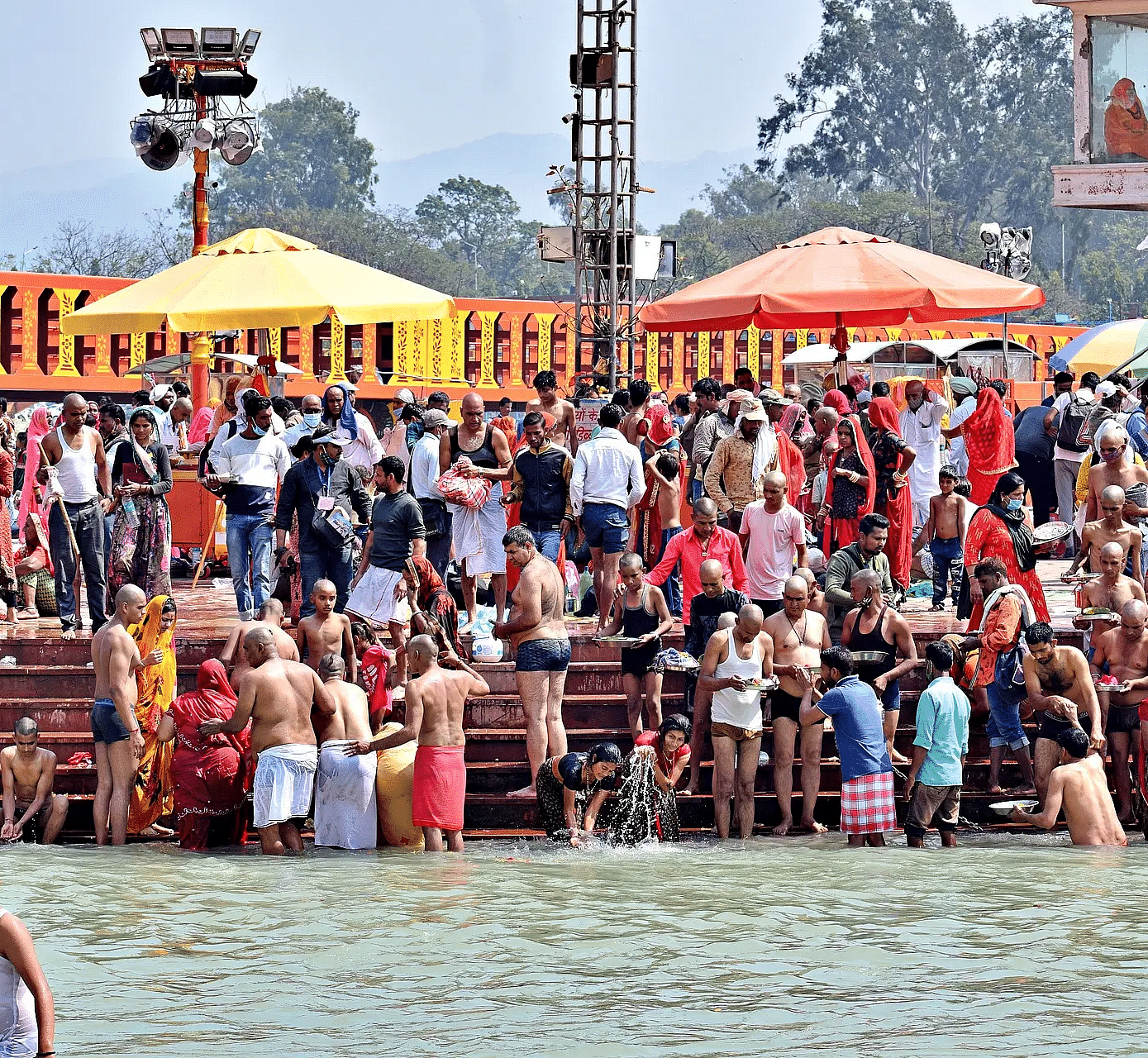 A huge group of devotees having a bath in the holy Ganges during the day time.