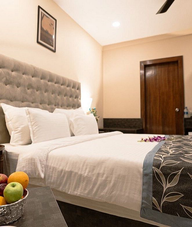 Elegant room with a bed, fruit bowl on the bedside table, and tufted headboard at The Verda de Miranda Resort.