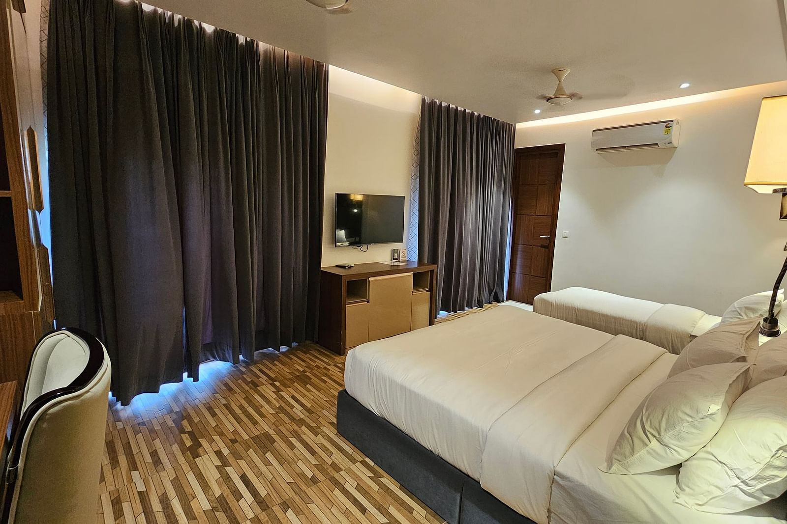 a family executive room at Eminence The Corbett with curtains drawn over the windows