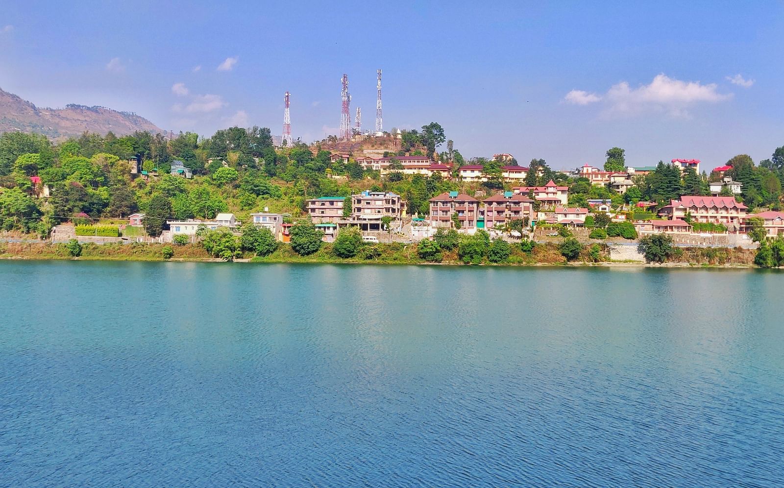 A wide shot of a tranquil lake surrounded by stunning mountains, reflecting the scenic landscape in the water.