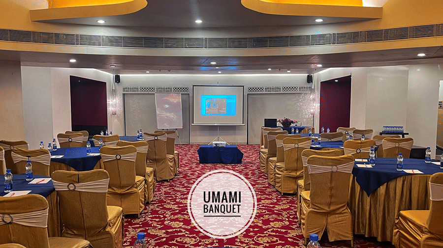 The Ummami Banquet Hall with chairs and tables arranged for a conference facing towards the stage - Senses Hotel