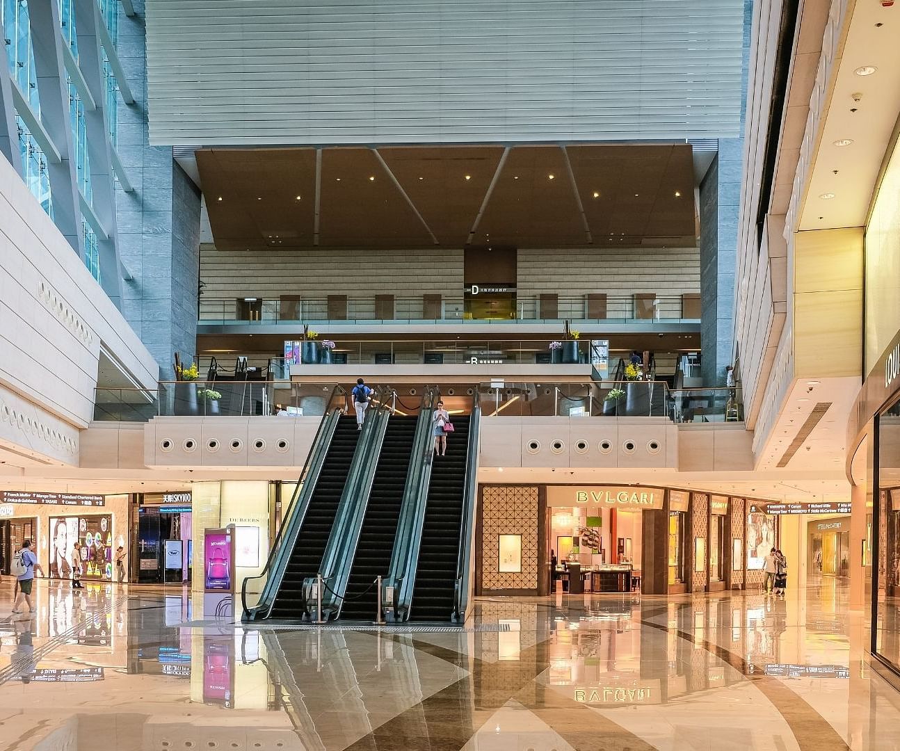 overview of A shopping mall with escalators in the centre and shops behind it near Rhythm Gurugram