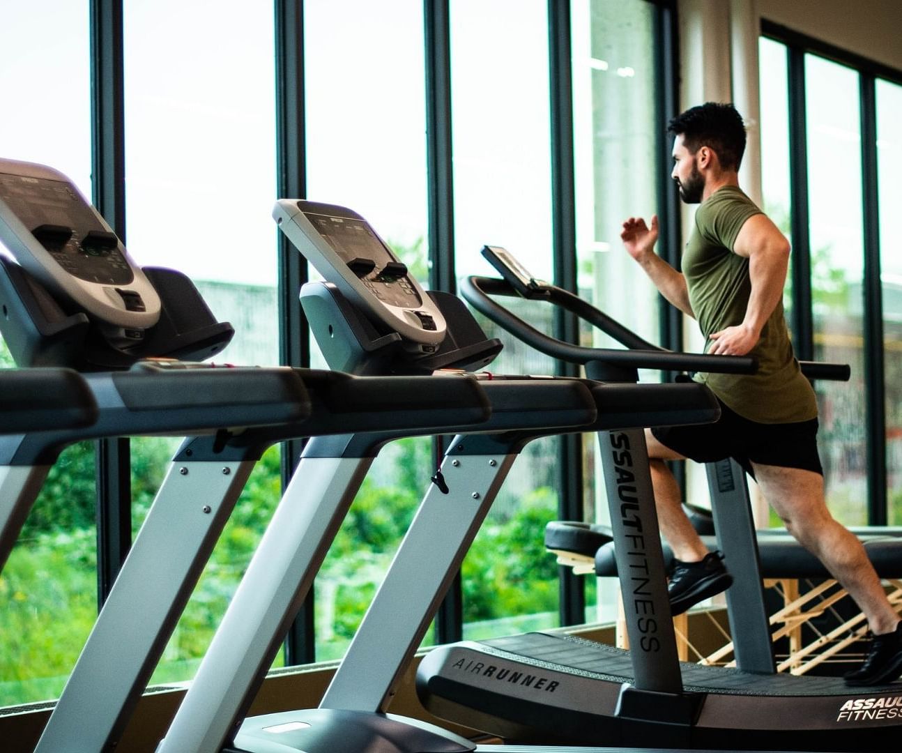 A person running on a treadmill with other treadmills next to him - Rhythm Gurugram