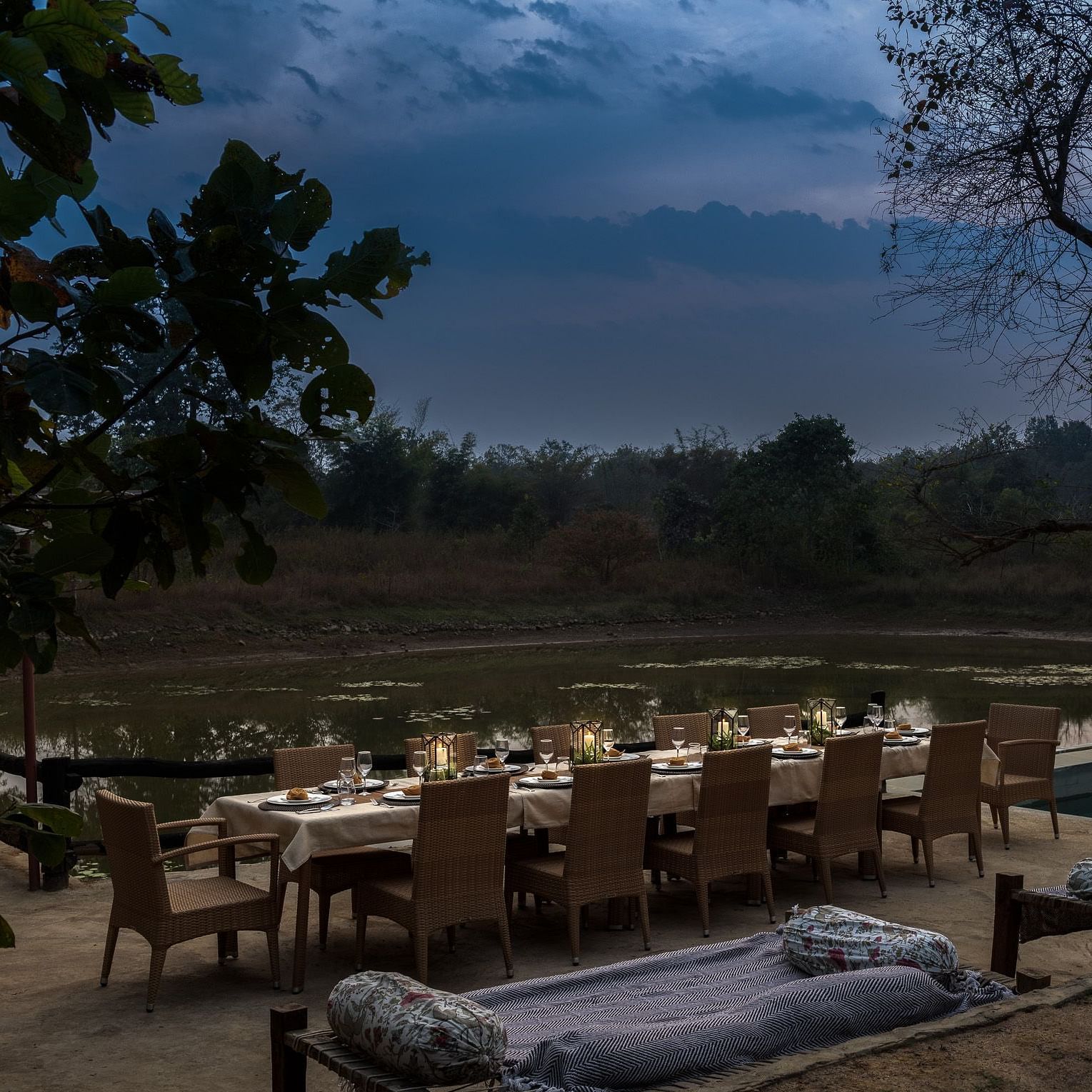 View of the dining setup near Swimming Pool at dusk at Saccharum Safari Lodge, Balaghat