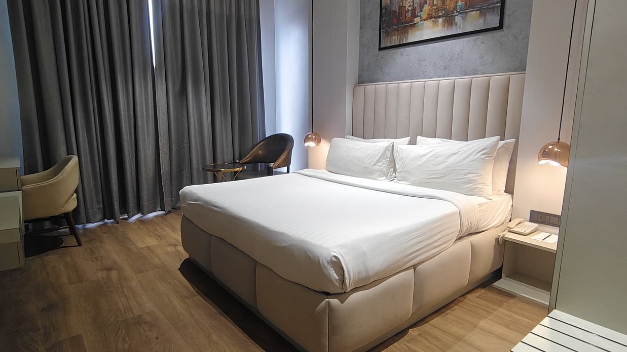 Room layout with bed, desk, and curtains at Sapna Clarks Inn.