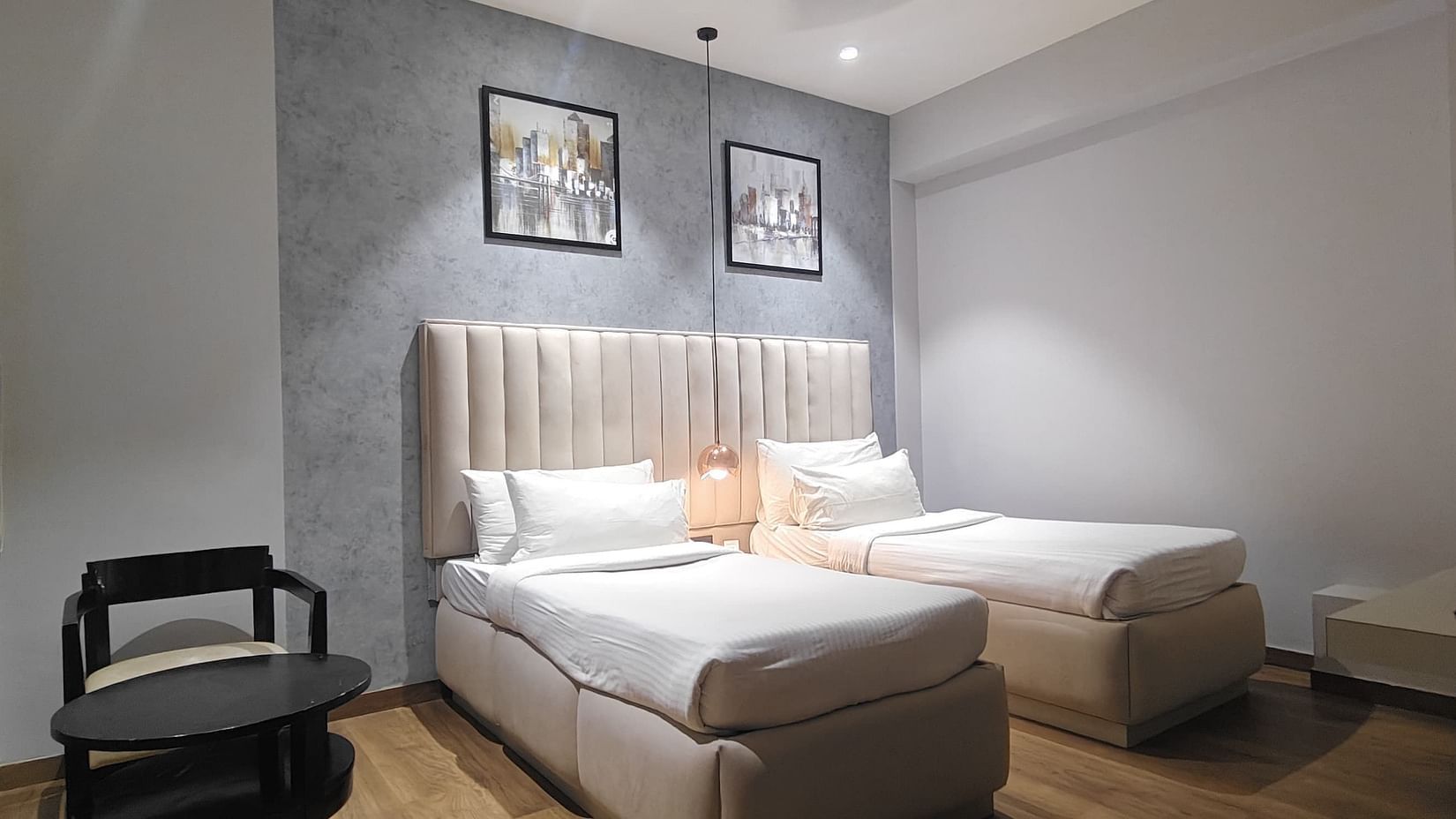 Spacious room with twin chairs, table, and a double bed at Sapna Clarks Inn.