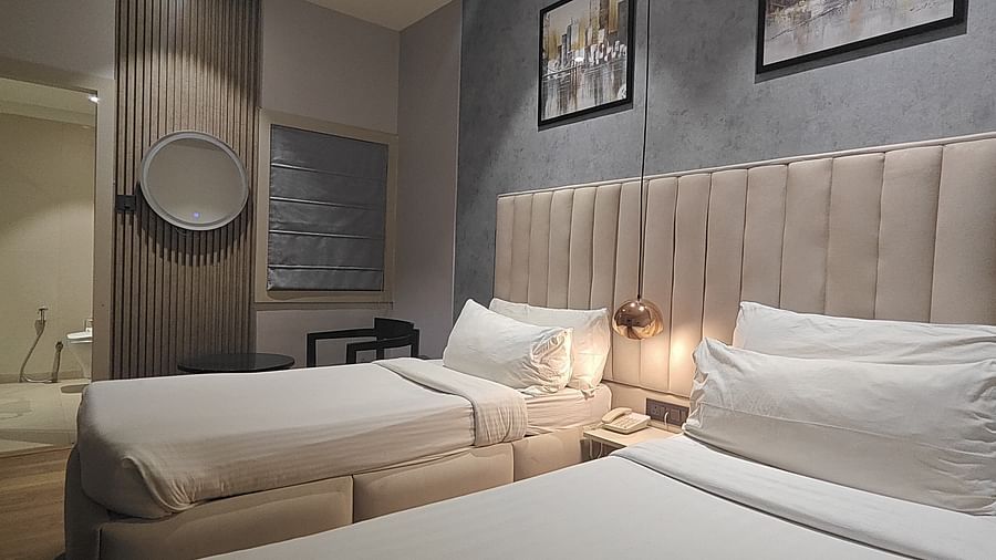 Room with a double bed, padded headboard, and wall art at Sapna Clarks Inn.