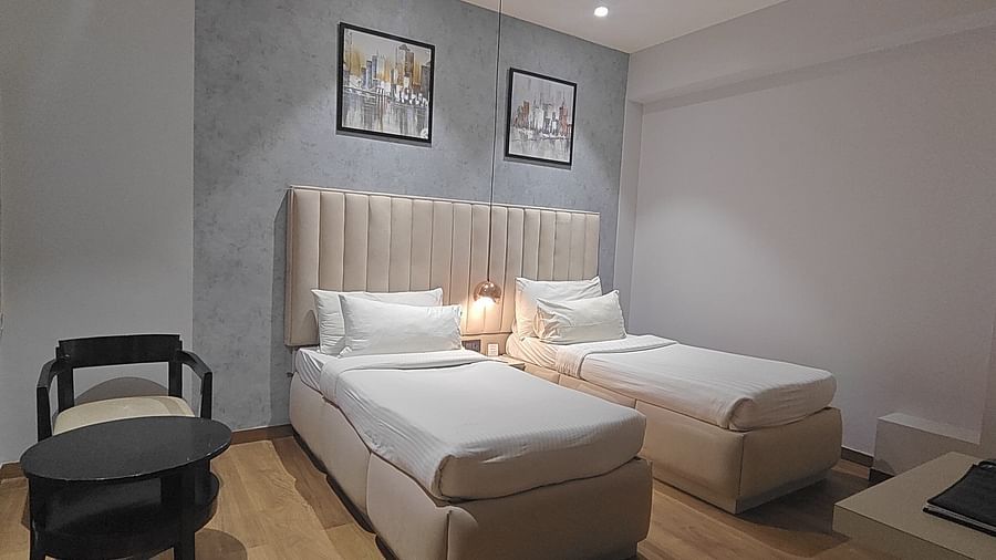 Bedroom with double bed, chair, and wall-mounted artwork at Sapna Clarks Inn.