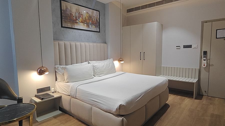 Bedroom with a large bed, bedside lamps, and framed pictures at Sapna Clarks Inn.
