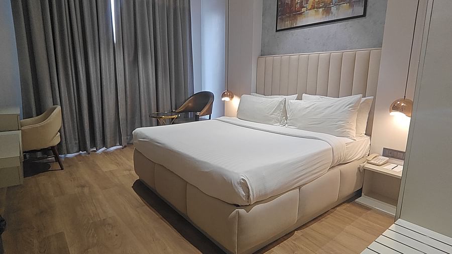 Spacious bedroom with double bed and seating area at Sapna Clarks Inn.
