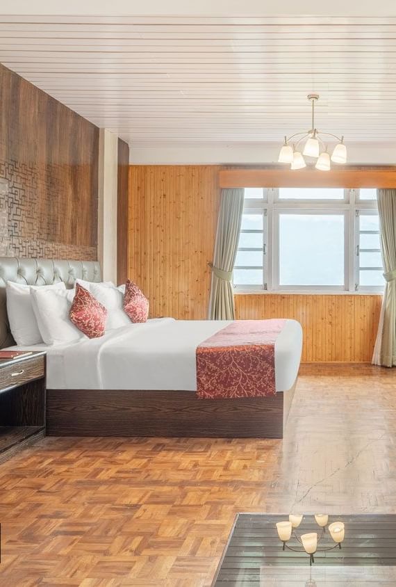 Side view of a room with bed and wooden wall decor at Summit Tashi Ghang Heritage Resort, Pelling