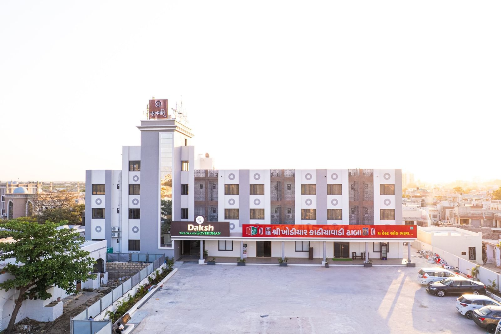 Expansive aerial view of Daksh The Grand Gowardhan, Dwarka, under bright sunlight, highlighting its layout and spacious grounds.