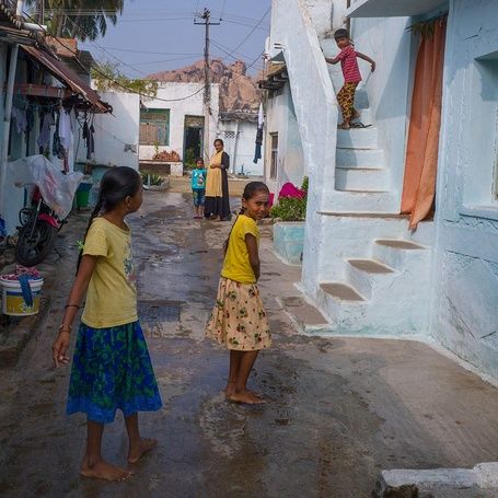 Village street scene in Hampi with blue houses.