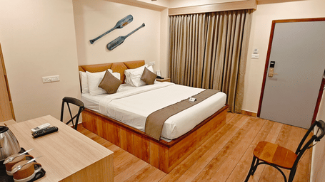 A spacious bedroom at Barren Villa with a double bed, wall-mounted TV, and large curtains | Arina Island Resort, Swaraj Dweep