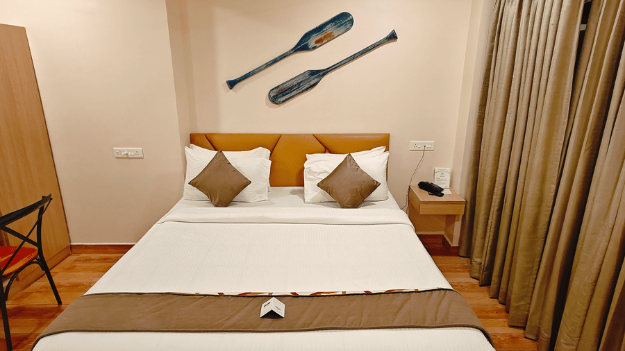 A neatly arranged bedroom at Barren Villa featuring a double bed, side table, and soft lighting