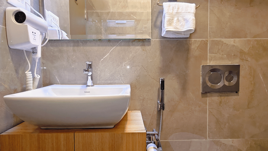 modern bathroom at Barren Villa with a washbasin, mirror, and neatly tiled walls