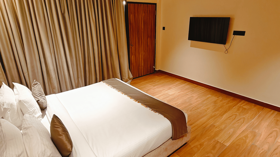A bedroom at Smith Balcony Villa featuring a double bed, TV, and floor-length curtains