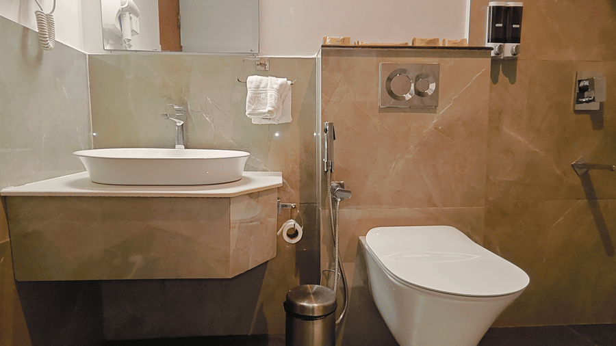 A modern bathroom at Ross Villa featuring a vanity counter, toilet, and tiled walls
