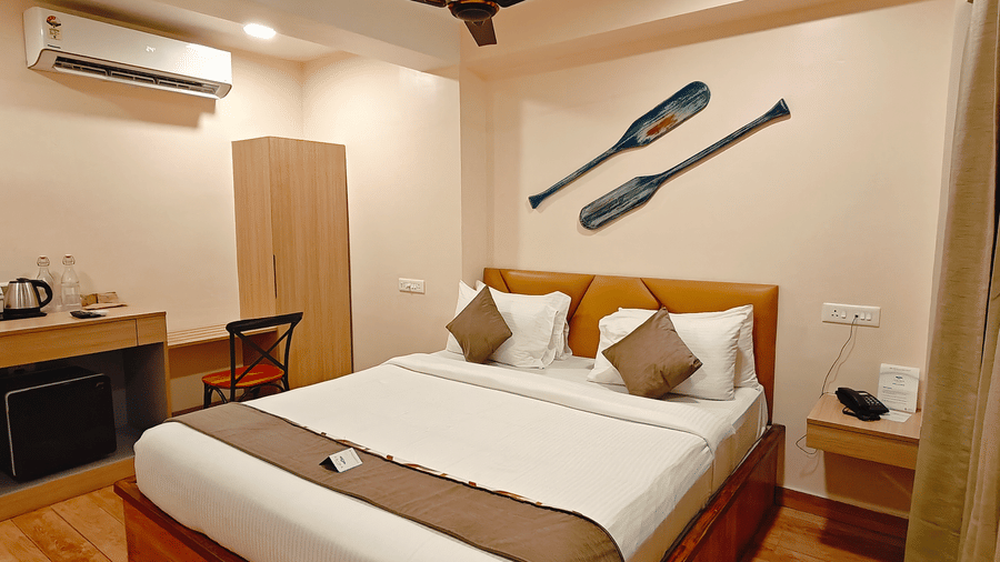 A well-furnished bedroom at Barren Villa featuring a double bed, side table, and a work desk with warm lighting | Arina Island Resort, Swaraj Dweep