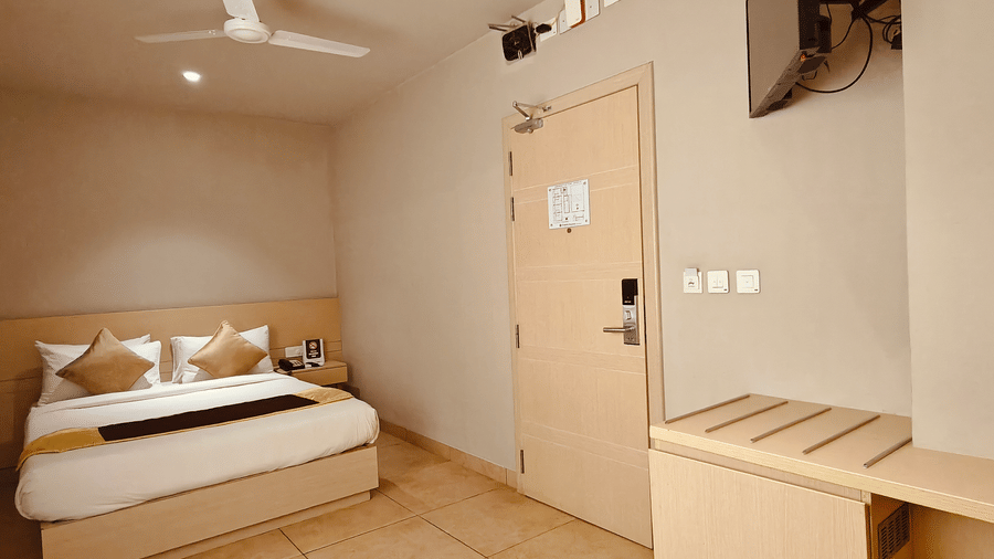 Interior layout of the Deluxe Single Room at Chola Dynasty, Kumbakonam showing the bed area, wall décor, and neatly arranged furnishings that create a welcoming and comfortable environment.