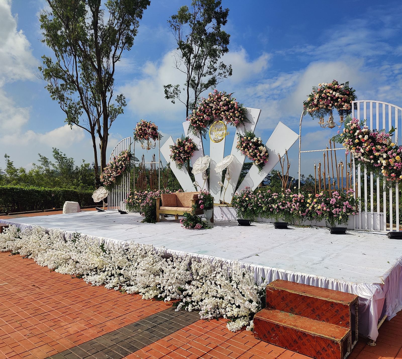 Decorated outdoor wedding stage with flowers and white linens | Open Deck