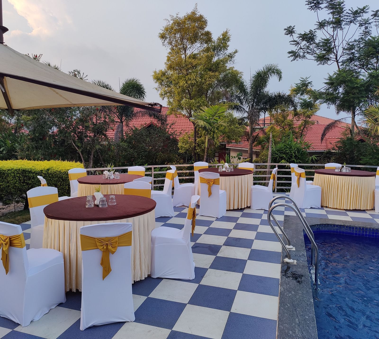 Outdoor event space with round tables and a swimming pool | Open Deck