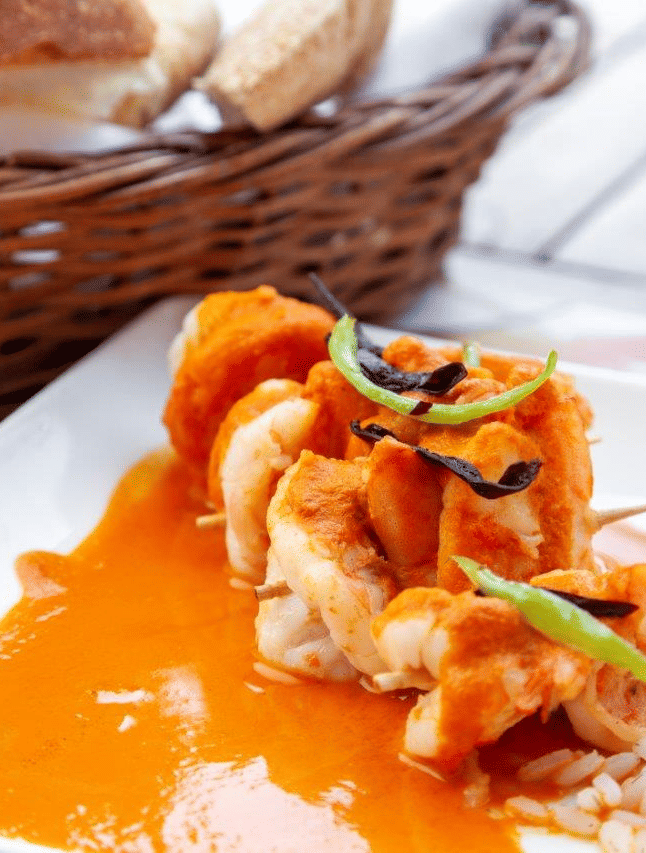 a close up shot of a curry with rice on the side on a plate - Caravela Beach Resort Goa