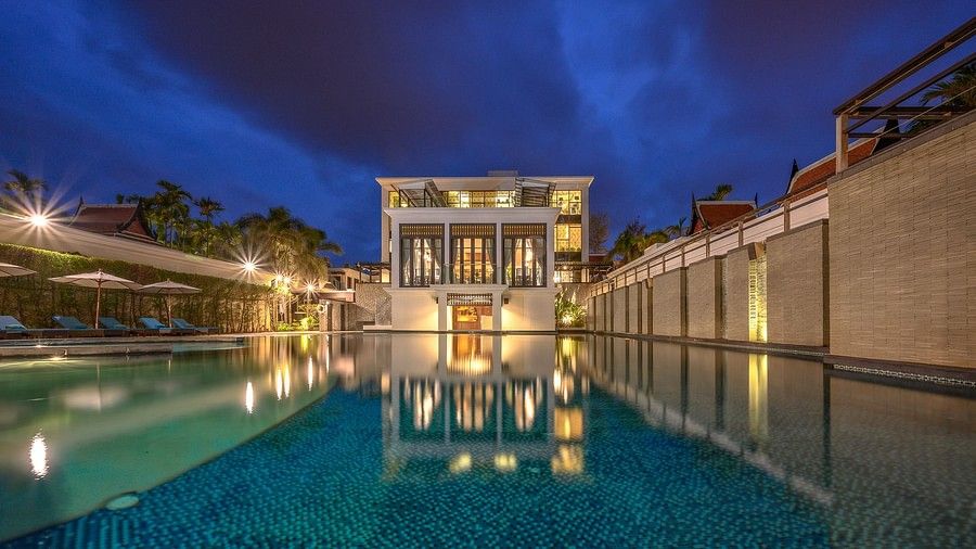facade image of the Maikhao Dream Villa Resort & Spa, Phuket with the swimming pool in the foreground on a late evening
