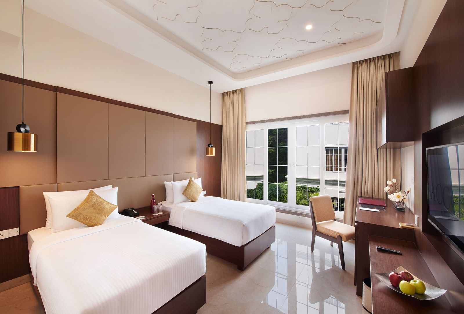 An image of a bedroom featuring two similar looking beds, a work desk and chair, and a flat TV screen - Accord Metropolitan