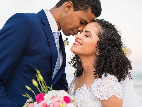 A couple in wedding attire standing in front of a beach - S Hotel Montego Bay, Jamaica