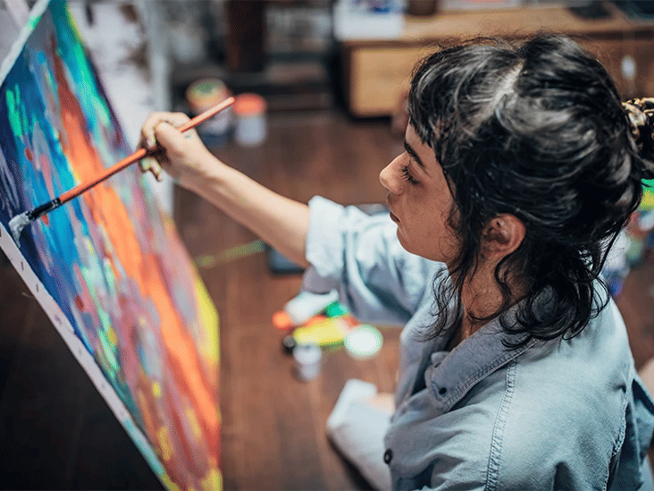 An artist painting on a large canvas in a creative studio setting 