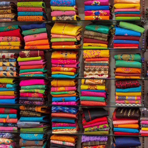 a shop with racks of sarees on display for people to buy