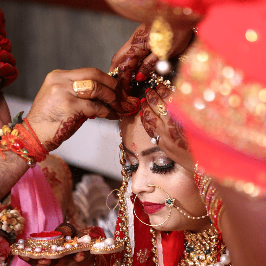 husband putting vermilion on his wife during their marriage ceremony