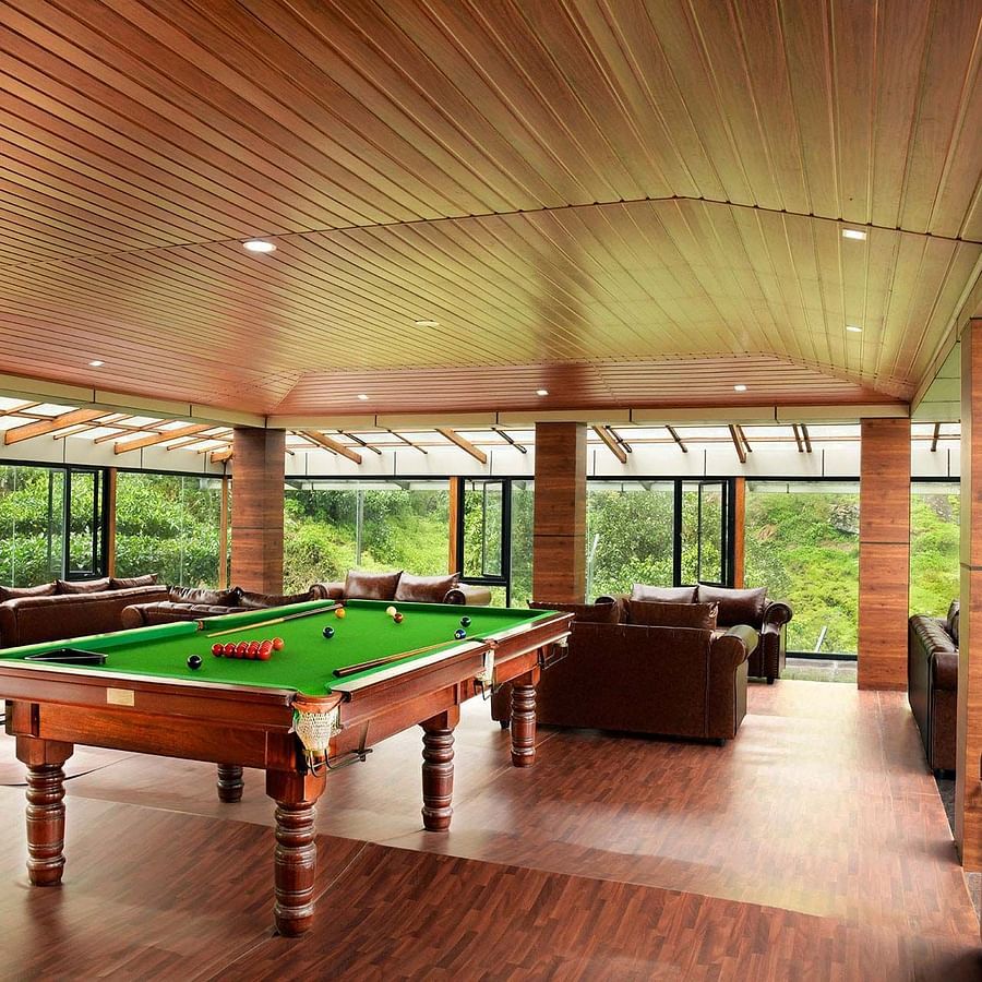 Shot of a billiard table at the hall of the villa Shot of the balcony at the villa with chairs kept | Ibex Stays and Trails, Valparai (Tale Rock)