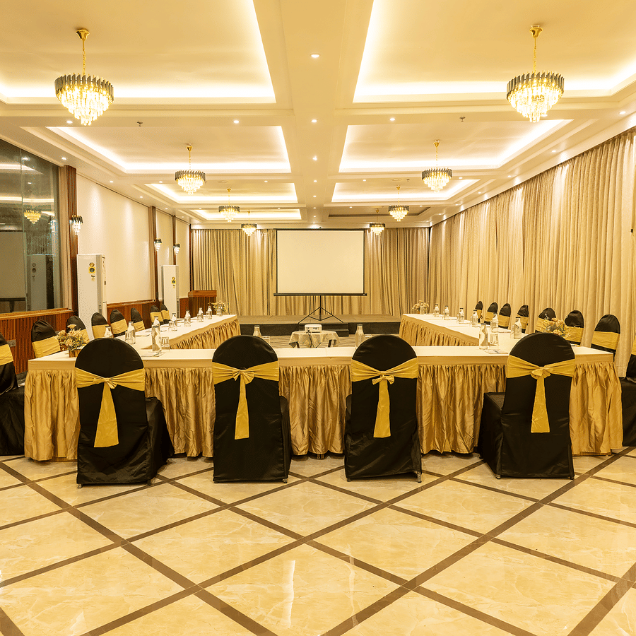 Banquet hall with gold-accented chair covers and bright lighting at Silver Sand Sea Princess Beach Resort, Port Blair.