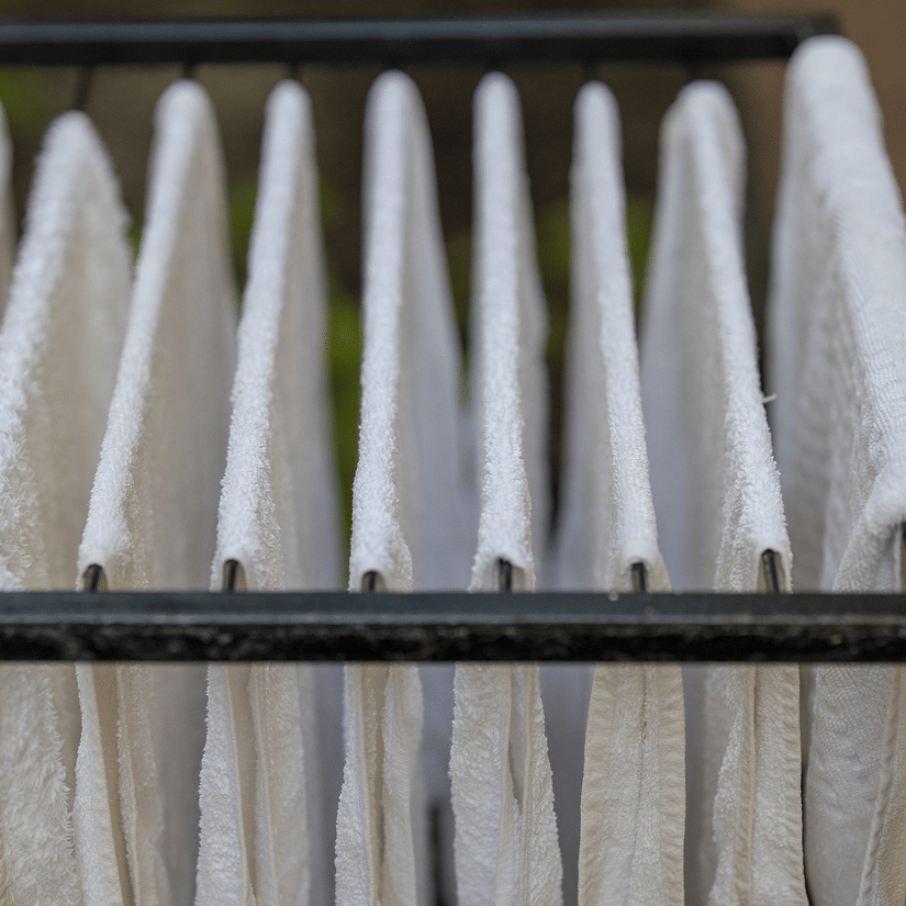 A close up of many towels kept on a metal rack for drying.