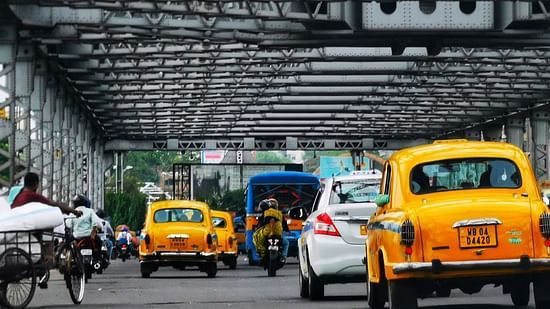 Yellow taxis traverse the Howrah Bridge