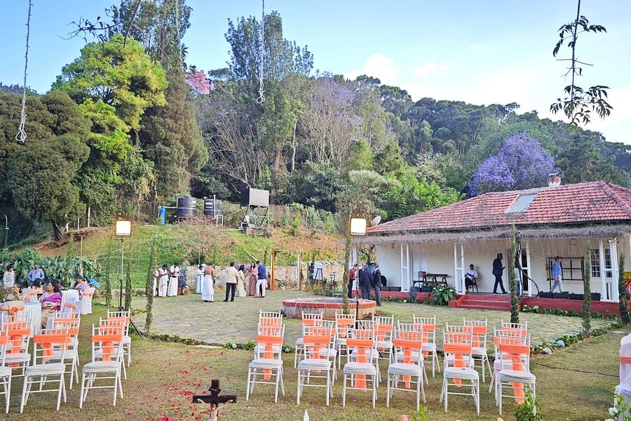 Wedding setup in Coonoor with rows of chairs and a central water feature under a tree adorned with purple flowers - Ibex Stays & Trails, Coonoor (Leewood).