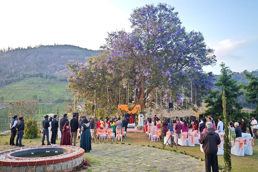 Panoramic view of an outdoor wedding ceremony with guests seated around a central lawn under trees in Coonoor - Ibex Stays & Trails, Coonoor (Leewood).