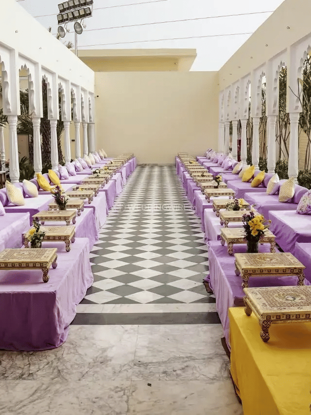 Long seating arrangement with low sofas and cushions lined along pillars at Beelwa Palace, Jaipur