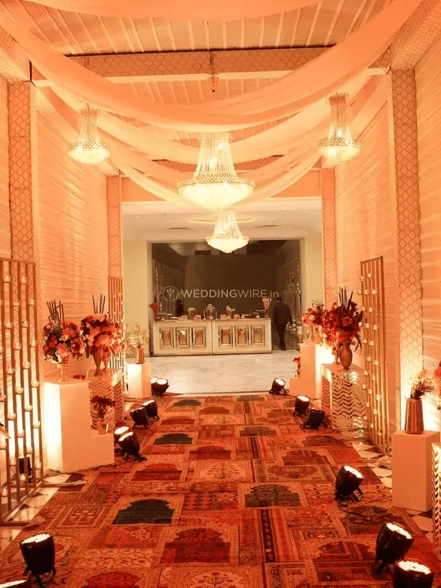 A corridor decorated with drapes and flowers, with seating along the sides at Beelwa Palace, Jaipur.